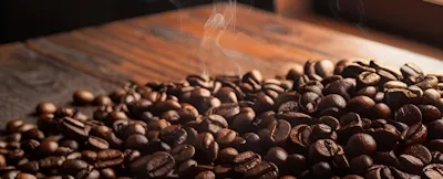 Tres profesionales conversan alrededor de una mesa con un cultivo de café al fondo.