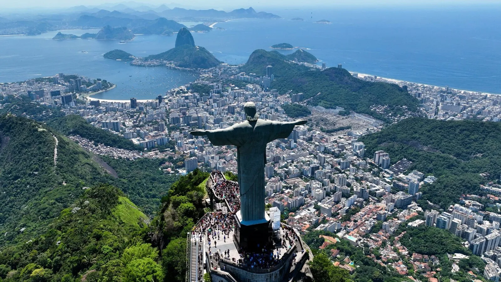 Vista oficial de Río de Janeiro con el Cristo Redentor, la bahía y las montañas bajo un cielo despejado.