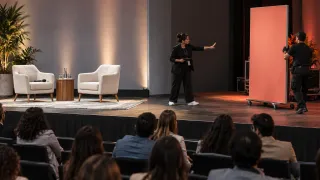 Una productora separa en el escenario una conversación editorial de una activación comercial visible para la audiencia.