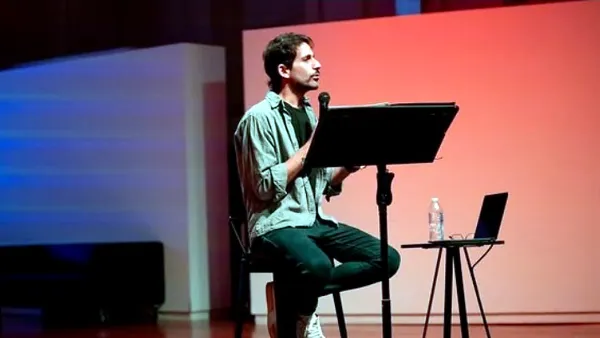 Intérprete de YO, sin culpa durante una presentación escénica con micrófono y atril