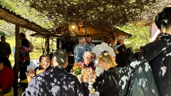 Participantes de Coffee LATAM 2026 conversan durante la visita de campo en una finca cafetera.